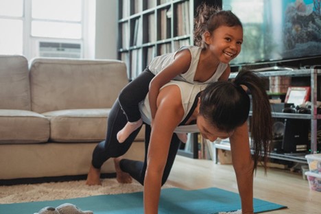 Source: https://www.pexels.com/photo/young-asian-woman-piggybacking-smiling-daughter-while-exercising-at-home-5094677/
